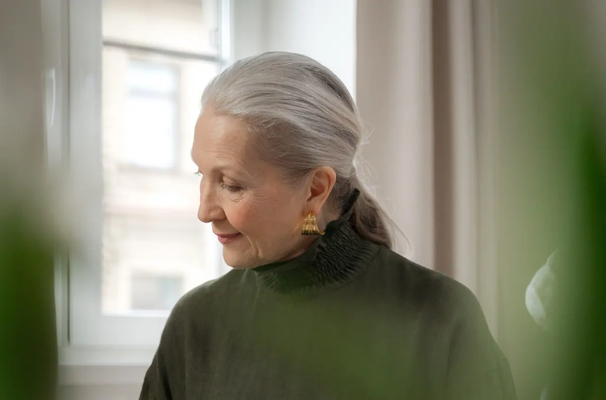 A woman reading quietly by a window at home