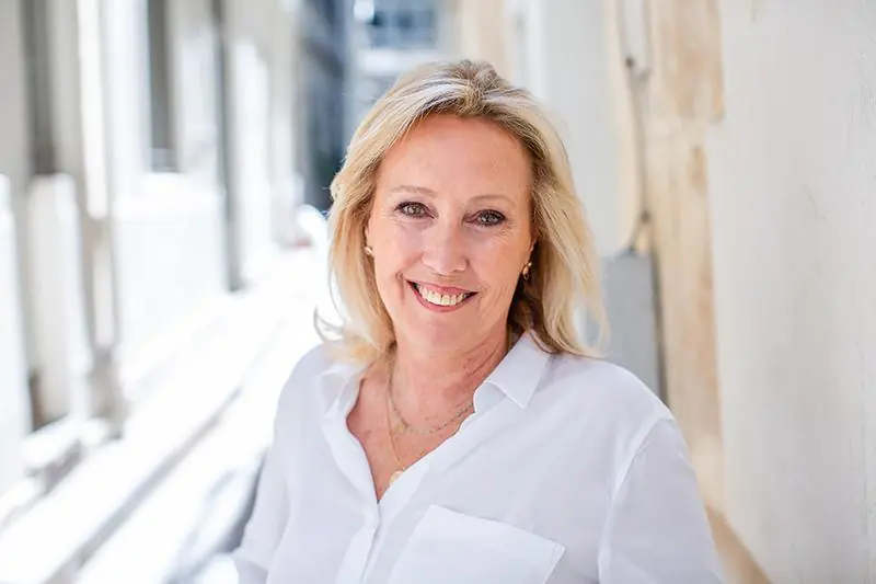 A woman smiling in a bright room, looking clear-headed and relaxed