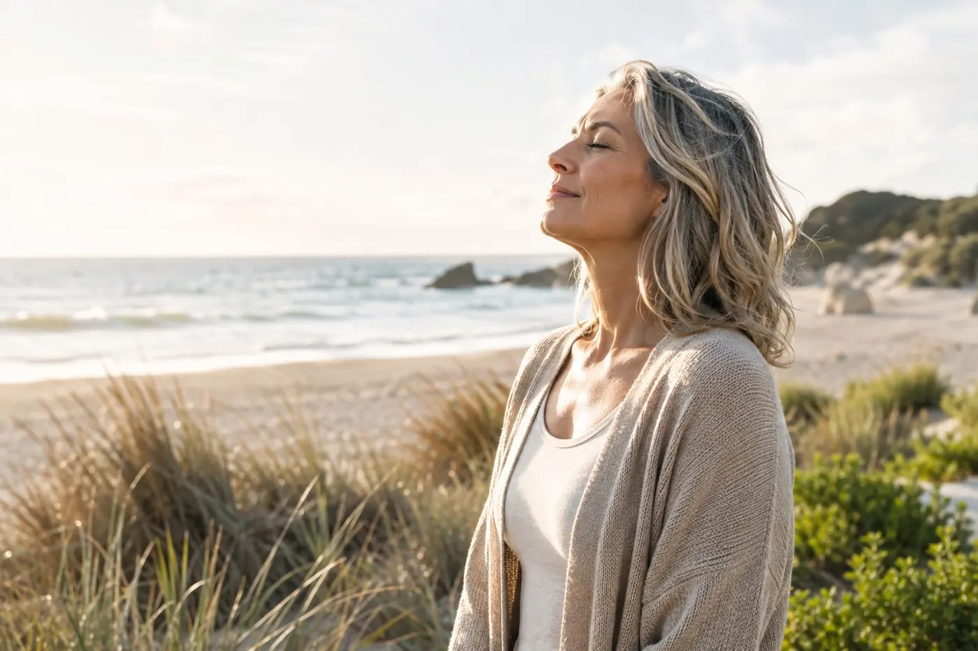 A woman with her eyes closed, enjoying a peaceful moment by the ocean